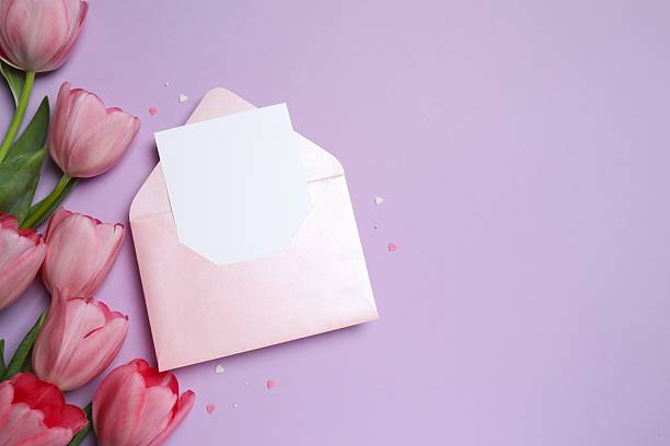 istock Beautiful fresh tulips with paper envelope on color background 2253895727