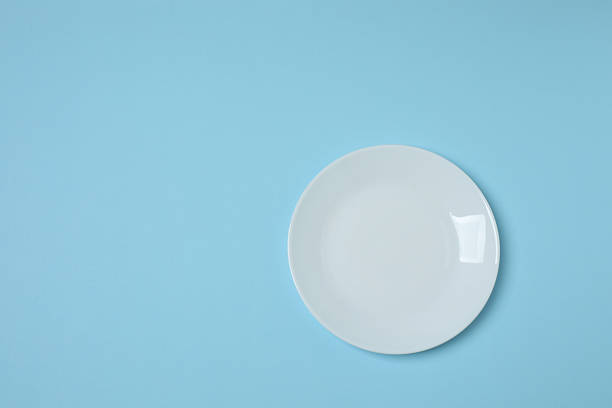 istock Empty plate and cutlery on colored background, top view 2253898728