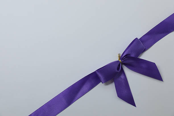 Bright bow with purple ribbon on a colored background