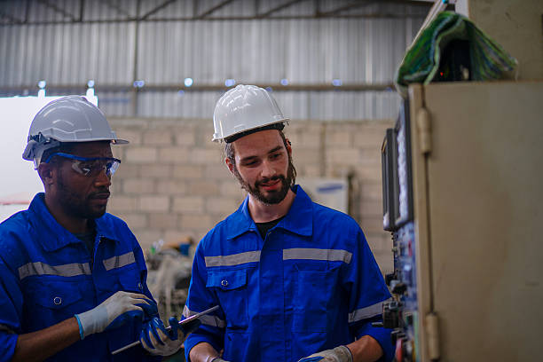 istock Blue collar workers are working at machine shop with welding robot arm. 2253899573