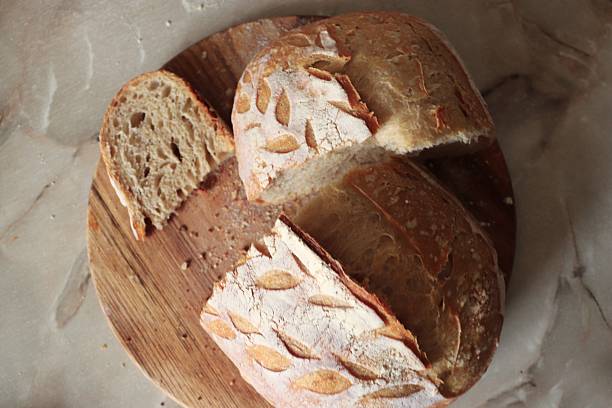 istock Artisan rustic bread with decorative scoring and airy crumb on wooden surface, perfect for bakery branding 2253902113