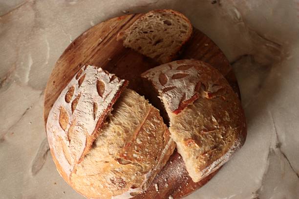 istock Artisan rustic bread with decorative scoring and airy crumb on wooden surface, perfect for bakery branding 2253902116