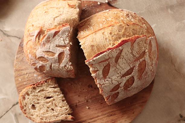 istock Artisan rustic bread with decorative scoring and airy crumb on wooden surface, perfect for bakery branding 2253902163