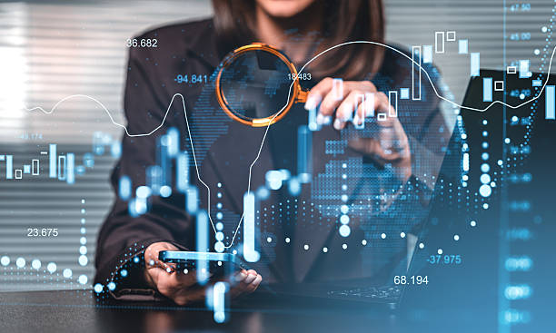 istock Businesswoman analyzing financial market chart data with magnify 2253902707