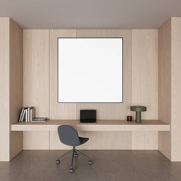 istock Modern interior workspace with blank framed poster mockup on wooden wall above minimalist desk setup and chair in clean light design layout. 3D Rendering 2253902934