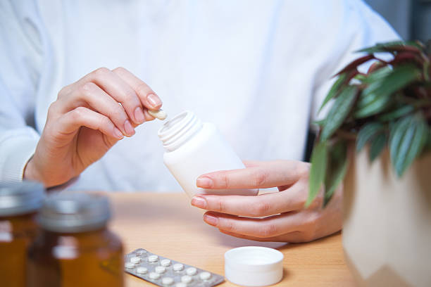 istock Woman holding a yellow pill. 2253903055