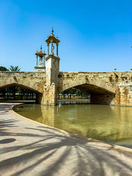 istock Golden monuments reflect in calm waters beneath ancient stone arches in a serene park, inviting exploration and wonder in the midday sun 2253903871