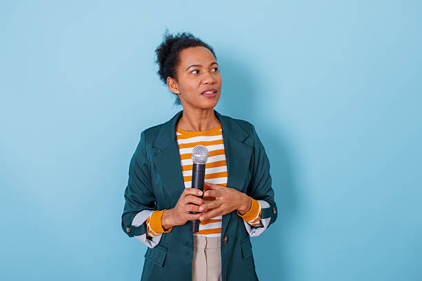 istock Black woman holding microphone speaking, communicating ideas during presentation or public interview 2253903929