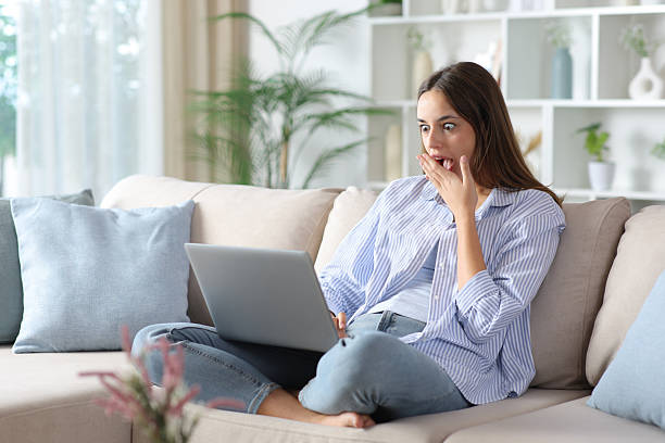 istock Amazed woman in blue at home checking laptop 2253907770