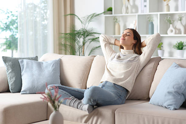 istock Relaxed woman in winter resting sitting on a sofa 2253907802