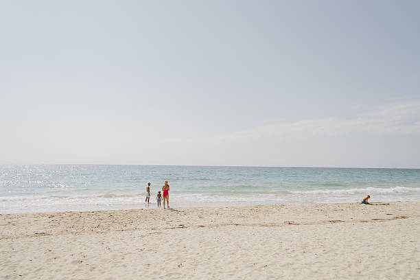 Photo of a young family with two young boys, spending quality time together while on a beach vacation