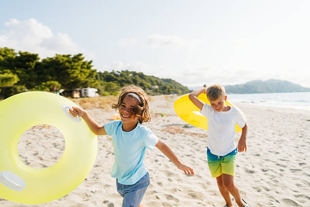 Photo of two young boys having fun on the beach while at summer vacation
