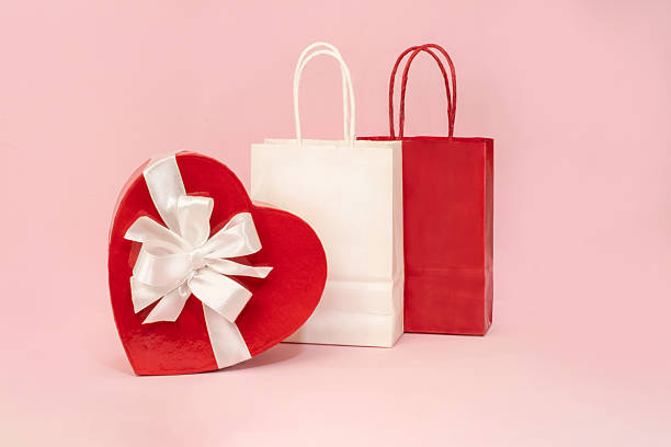 istock A holiday backdrop with a heart-shaped cardboard box with a bow, a gift bag 2253913692