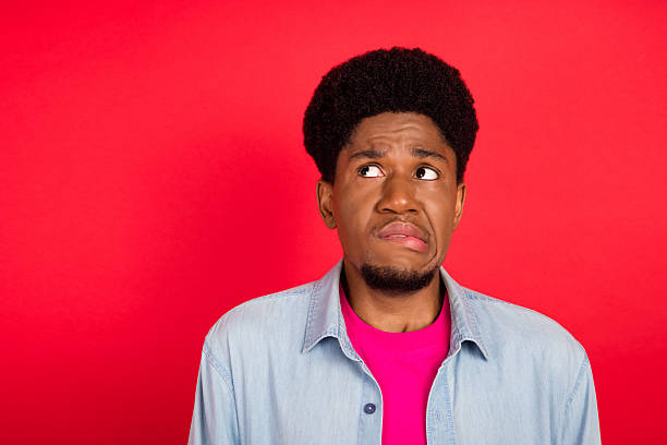 istock Portrait of attractive cheerful curious brunet guy thinking copy empty space isolated over bright red color background 2253914725