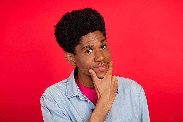 istock Portrait of attractive cheerful curious brunet guy thinking copy empty space isolated over bright red color background 2253914728