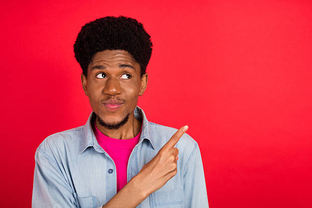 istock Portrait of attractive cheerful curious brunet guy thinking copy empty space isolated over bright red color background 2253914772