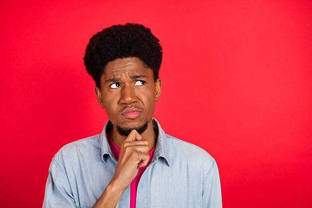 istock Portrait of attractive cheerful curious brunet guy thinking copy empty space isolated over bright red color background 2253914775