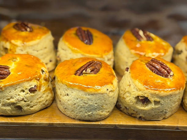 Stock photo shows freshly baked plain scones biscuits filled with cranberries and raisins, brushed with eggwash for a golden finish. Captured in warm, natural light, these classic bakery treats are ideal for afternoon tea, café menus, food blogs, advertisements
