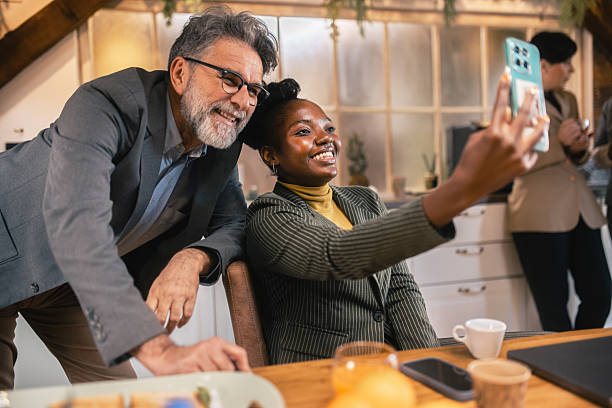 istock Business colleagues taking a selfie together during break in office kitchen 2253923755