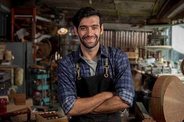 istock Smiling Carpenter Portrait in Woodworking Workshop, Confident Craftsman in Apron 2253924695