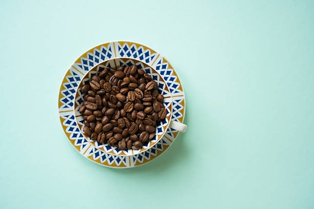 Freshly roasted coffee beans in a classic porcelain coffee cup, the epitome of afternoon coffee