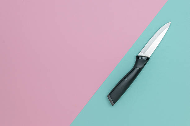 istock Minimalist Kitchen Concept: Black Knife on Pastel Pink and Blue Background 2253928228