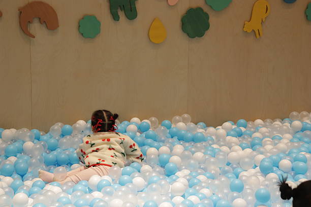 istock Toddler Exploring an Indoor Ball Pit with Copy Space 2253929946