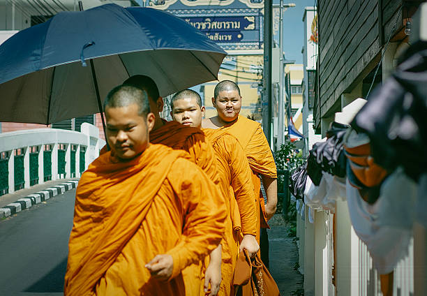 Buddhist monks walk along a street in Bangkok, Thailand, December 19, 2025