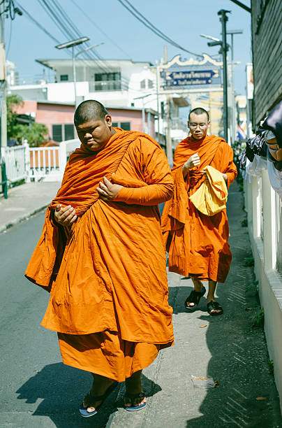 Buddhist monks walk along a street in Bangkok, Thailand, December 19, 2025