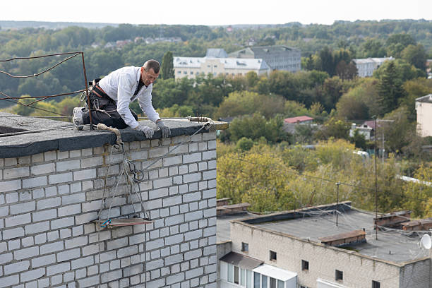istock Construction worker lowers a safety harness and a seat for working at height from the roof. 2253934018