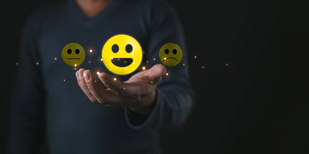 istock A person holds glowing emoticons showing happy,neutral,and sad faces symbolizing think positive mindset,customer satisfaction,feedback,emotions,evaluation,and choice in expressing experiences. 2253934241