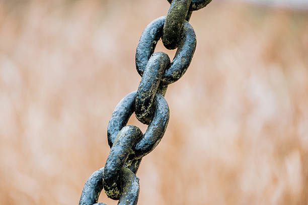 Old iron anchor chain. Rusty chain links defocused diagonally. Simple background.