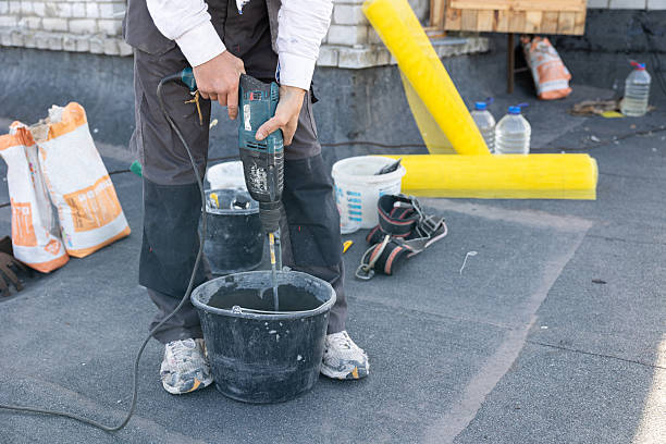Road worker breaking street asphalt with jackhammer