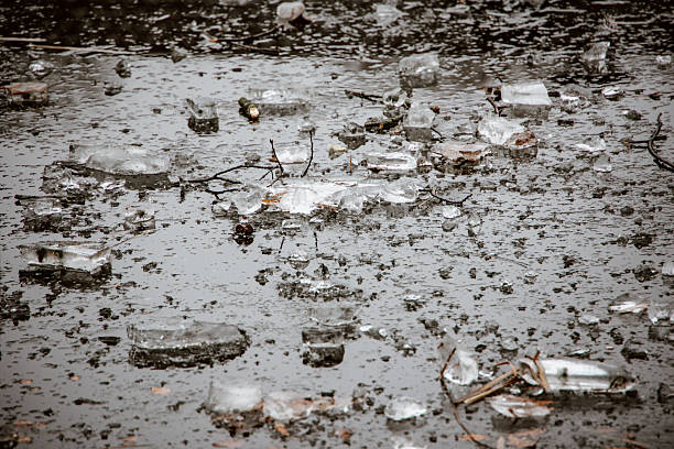 Broken winter ice on frozen pond surface. Day outdoors