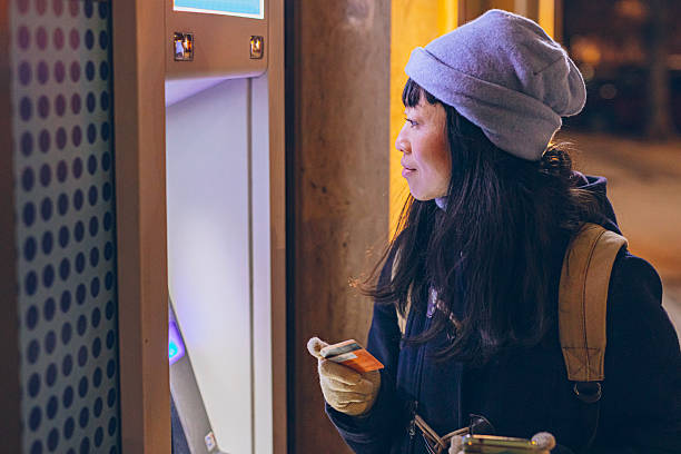 istock Woman Withdrawing Money from ATM at Night 2253937018