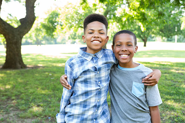 istock Two smiling young Black boys embracing affectionately outdoors on a sunny day. 2253938164