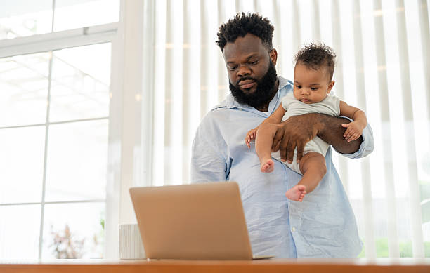 istock Father working from home while holding his baby son 2253938898