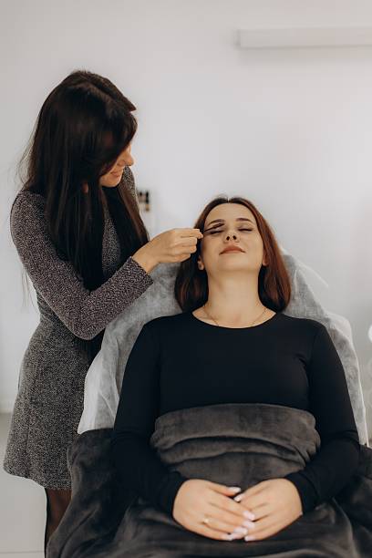istock Beautician applying mascara on client's eyelashes in salon 2253942372