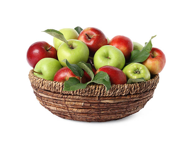istock Fresh ripe apples with green leaves in wicker basket isolated on white 2253948655