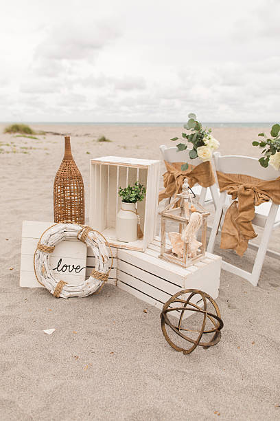 Soft Pastel Beach Wedding Decor with Burlap, Rustic White Wood, Rattan, Ivory-Colored Roses, Cream Stock Spray Flowers & Sage-Green Eucalyptus for a Modern Rustic Beach Wedding in Jupiter, Florida in December 2025.
