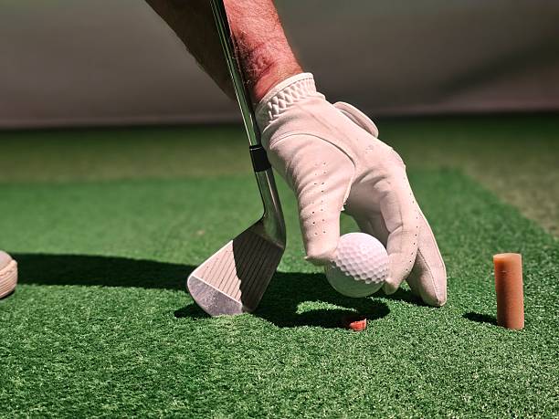 istock Hand prepares to strike a golf ball on a practice green during a training session 2253954757