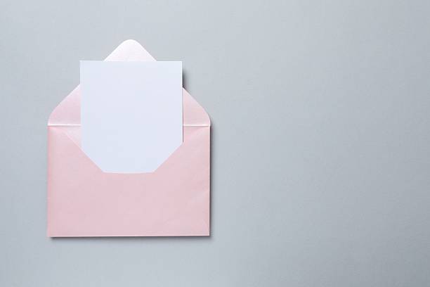 istock Paper envelope with white card on grey background 2253967481