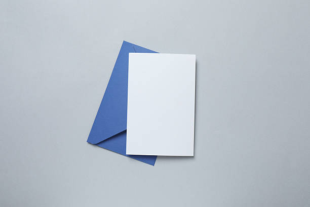 istock Paper envelope with white card on grey background 2253967488