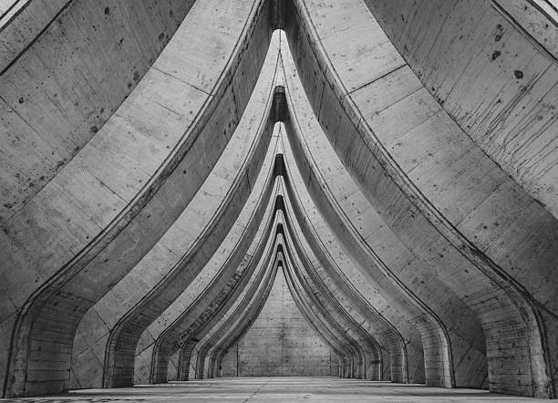 A stark modern brutalist concrete interior structure with curved patterns in at the parking garage in Sihlcity, Zurich, Switzerland, in black and white
