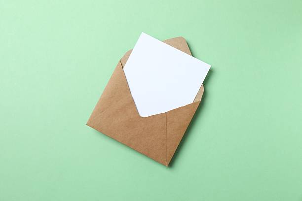 istock Paper envelope with white card on green background 2253968852