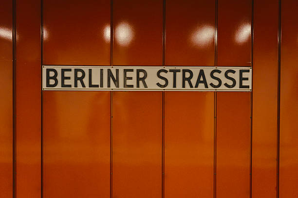 Black and white image of commuters outside Berliner Strasse U-Bahn (Berlin street underground) station  in Berlin - Germany