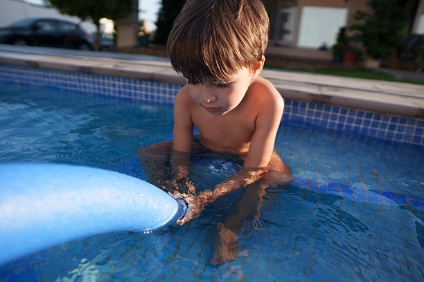 istock Child playing with pool noodle in swimming pool 2253969595