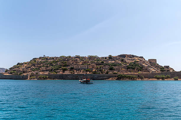 Visitors explore Spinalonga Island, enjoying its historical sites and beautiful surroundings.
