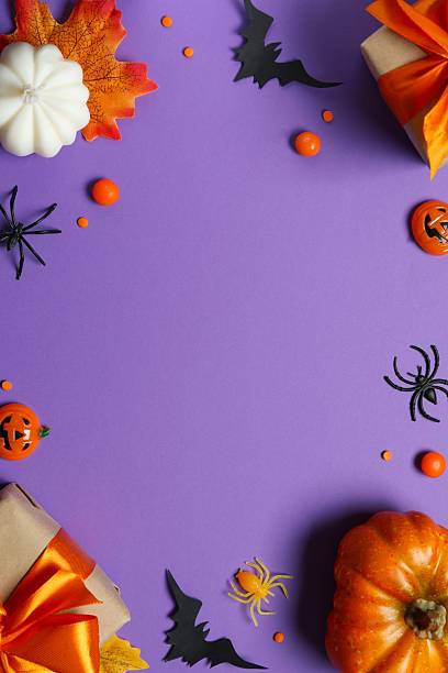 istock Halloween composition. Gift boxes, pumpkins, black bats and spiders on bright purple background, top view 2253970027