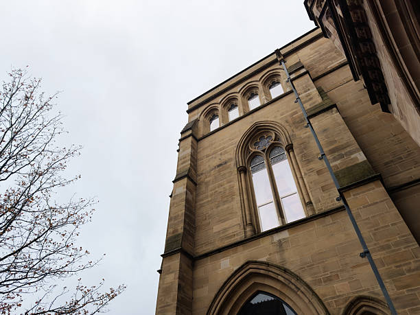 Manchester, UK - December 06, 2025: Gothic stone facade with tall arched window and decorative detailing in Manchester UK.